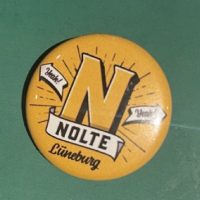 Runder gelber 25mm Ansteck-Button mit dem Logo des Brauhaus Nolte Lüneburg und der Aufschrift „Yeah! Nolte Lüneburg“.